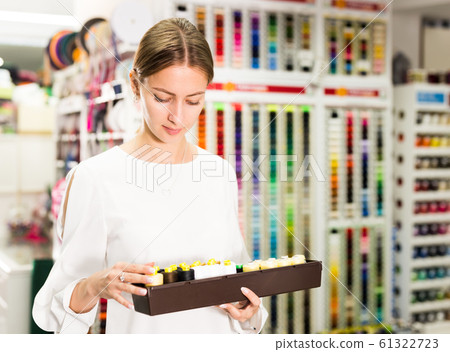Woman choosing threads for dressmaking Woman choosing threads for dressmaking 61322723