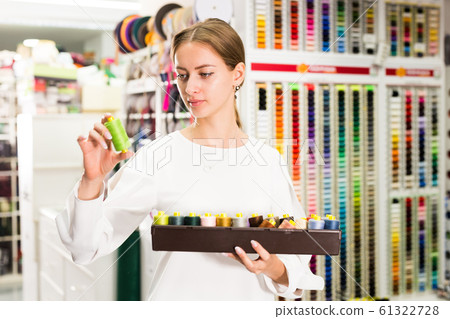 Woman choosing threads for dressmaking Woman choosing threads for dressmaking 61322728