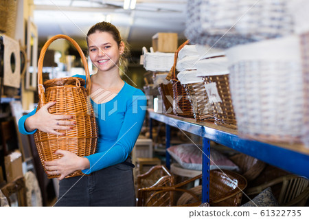 Female teen standing with wicker basket 61322735