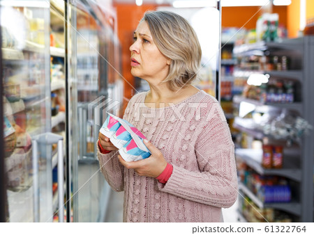 Mature woman choosing dairy products Mature woman choosing dairy products 61322764