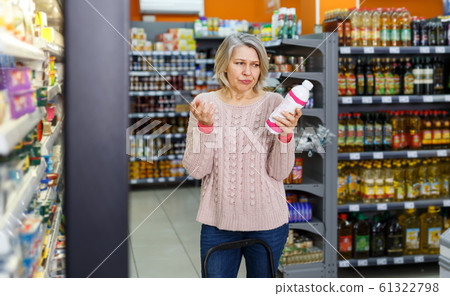 Amazed blonde female reading contents of products 61322798