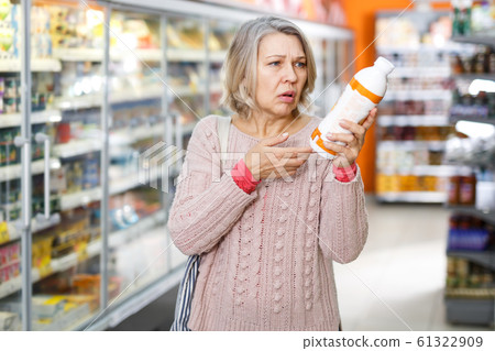 Shocked ordinary female reading product label Shocked ordinary female reading product label 61322909