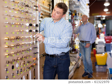Portrait of man selecting furniture fittings in household department 61322970