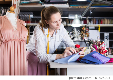 Woman is thinking about modern design near mannequin for new fashion collection Woman is thinking about modern design near mannequin for new fashion collection 61323004