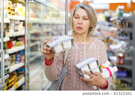 Amazed adult woman reading contents of goods Amazed adult woman reading contents of goods 61323162