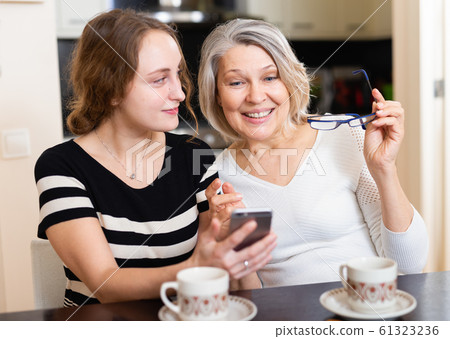Mother with daughter using smartphone Mother with daughter using smartphone 61323236