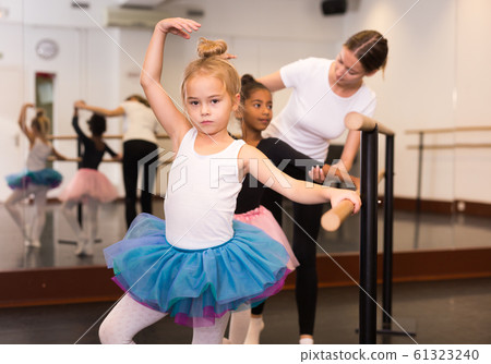 Teacher helping her little ballerinas 61323240