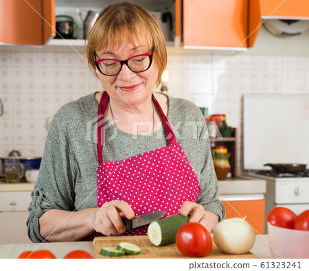 Mature housewife cutting vegetables for salad 61323241