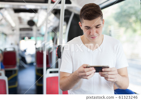 Man using smartphone in public transport Man using smartphone in public transport 61323246