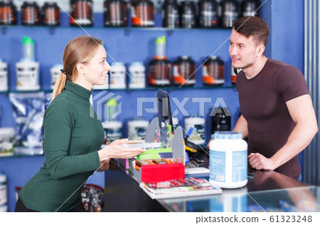 Girl buying sport food supplements Girl buying sport food supplements 61323248