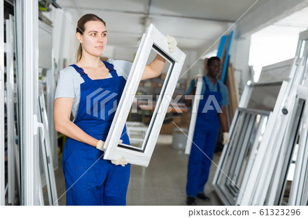 Portrait of woman worker who is standing with window frame Portrait of woman worker who is standing with window frame 61323296