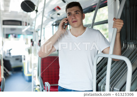 Passenger talking on phone in bus Passenger talking on phone in bus 61323306