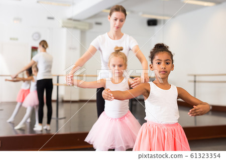 Dance teacher helping her little girls students 61323354