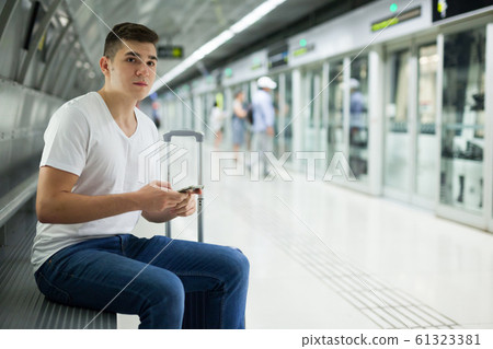 Man using phone in underground carriage Man using phone in underground carriage 61323381