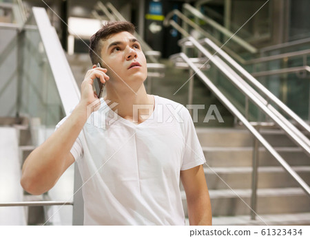 Passenger holding his smartphone on stairs Passenger holding his smartphone on stairs 61323434
