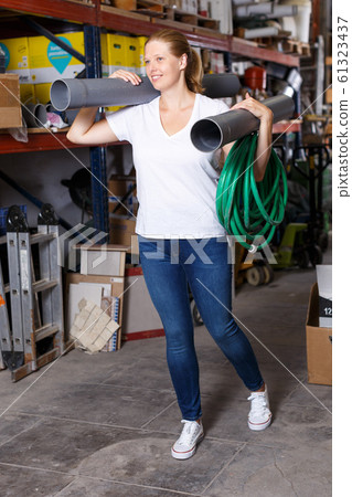Young female customer walking with construction materials during shopping 61323437