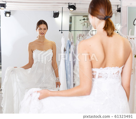 Girl fitting wedding dress 61323491