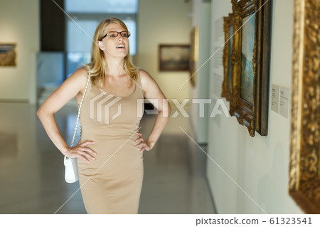 Woman wearing glasses looking at pictures 61323541