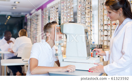 Teenager receiving eye examination with female ophthalmologist 61323592