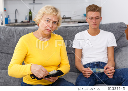 Woman giving money her adult son 61323645