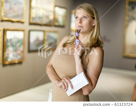 Woman holding brochure in museum of arts Woman holding brochure in museum of arts 61323724