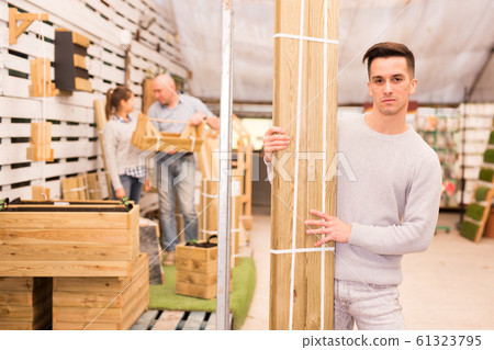 Young man buying wood panels Young man buying wood panels 61323795