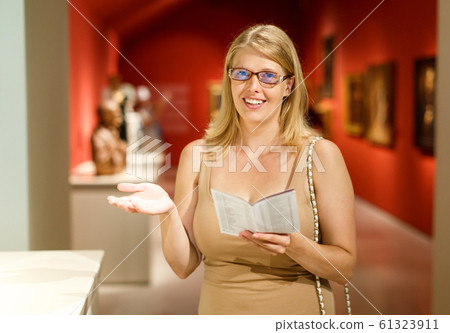 Woman holding brochure in museum of arts 61323911