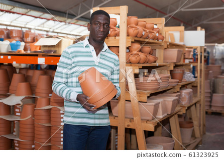 Man choosing pots for flowers in gardening market 61323925