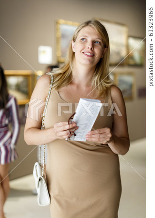 Woman with booklet looking at exhibits 61323966