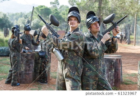 Two men in camouflage with guns ready for playing paintball with friends 61323967