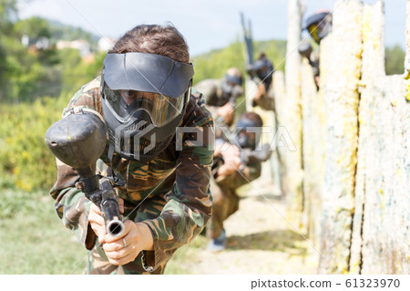Female paintball player aiming in shootout Female paintball player aiming in shootout 61323970