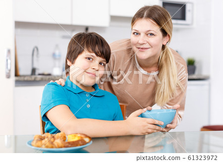 Mother and son eating at kitchen Mother and son eating at kitchen 61323972