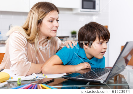 Family doing homework at kitchen Family doing homework at kitchen 61323974