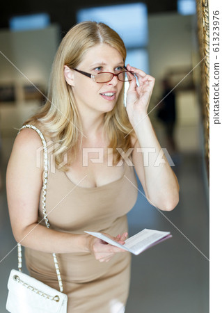 Woman trying to see picture Woman trying to see picture 61323976