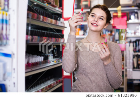 female customer looking for lipstick in cosmetics shop female customer looking for lipstick in cosmetics shop 61323980