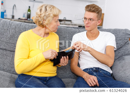 Mature woman giving pocket money son 61324026