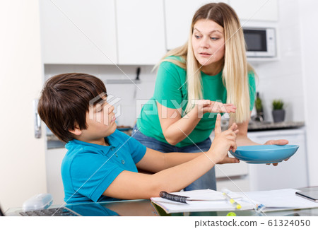 Displeased boy refusing to eat 61324050