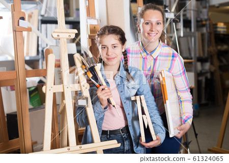 Mother and daughter standing among art supplies Mother and daughter standing among art supplies 61324065