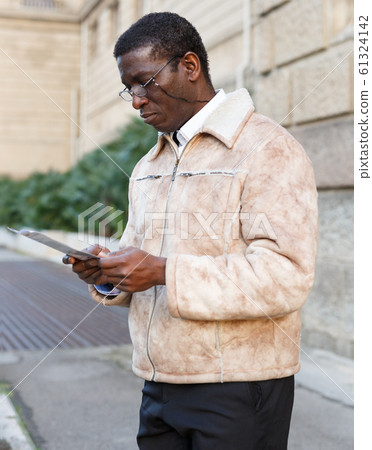 Man in warm jacket reading guidebook 61324142