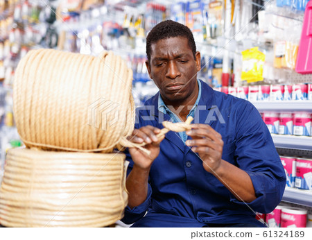 Confident African-American handyman choosing materials for overhauls in household store Confident African-American handyman choosing materials for overhauls in household store 61324189
