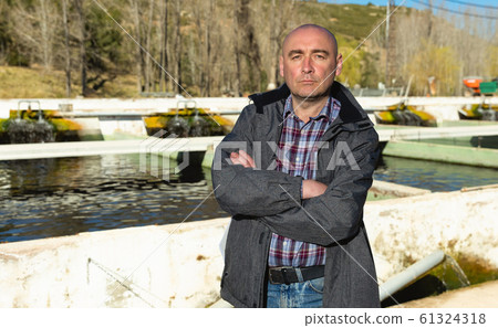 Confident male owner of trout farm 61324318
