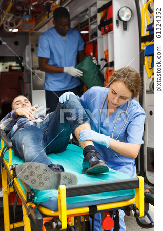 Doctors providing medical care to injured man 61324352