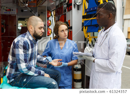 Ambulance team providing medical care to patient Ambulance team providing medical care to patient 61324357