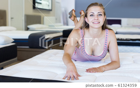 Sexy girl lying on new mattress in furniture store Sexy girl lying on new mattress in furniture store 61324359