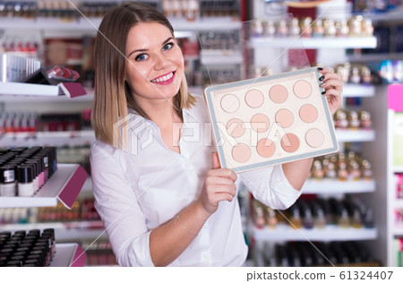 friendly female seller offering compact powder at store friendly female seller offering compact powder at store 61324407