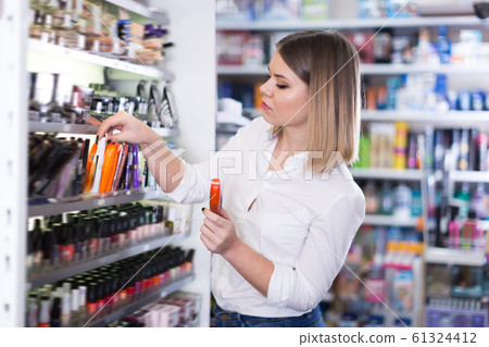 Attractive young woman looking for new mascara 61324412