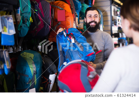 young pair examining rucksacks in sports equipment store 61324414