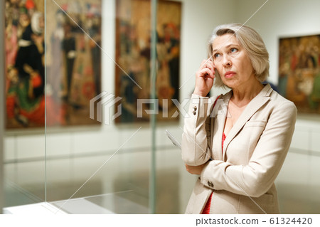 Mature woman visiting museum Mature woman visiting museum 61324420