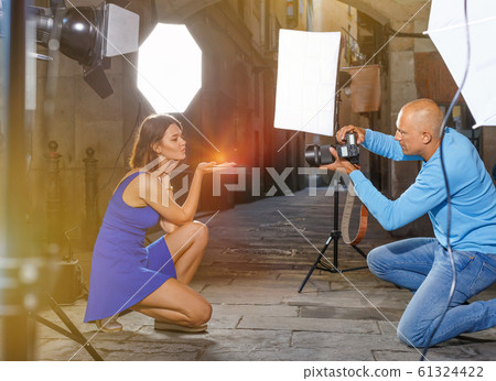 Professional photo shooting outdoors. Attractive female model po Professional photo shooting outdoors. Attractive female model po 61324422