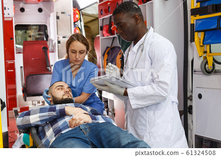 Doctor asking patient to sign in logbook Doctor asking patient to sign in logbook 61324508